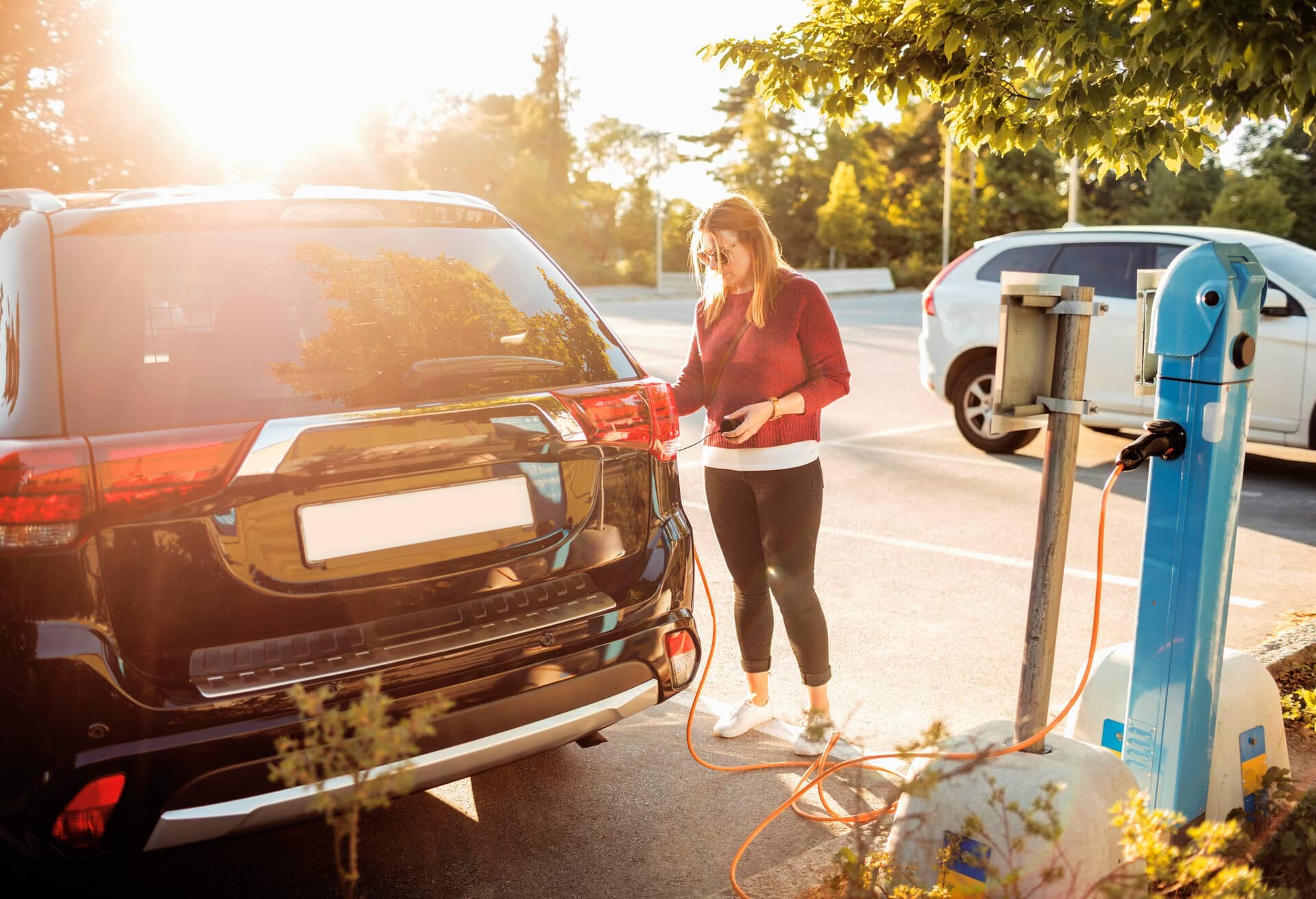 Una ragazza mentre ricarica un'auto elettrica.