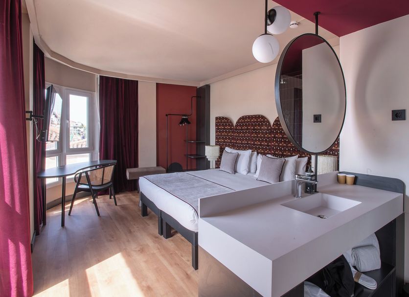 Habitación del hotel con espejo circular y distribución abierta